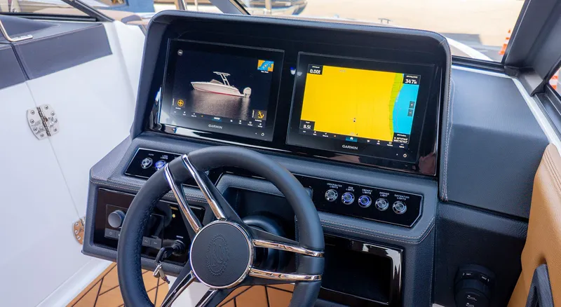 Slide: The Image of The image shows the cockpit of a Cobalt R6B boat with two navigation screens and a steering wheel. - 28