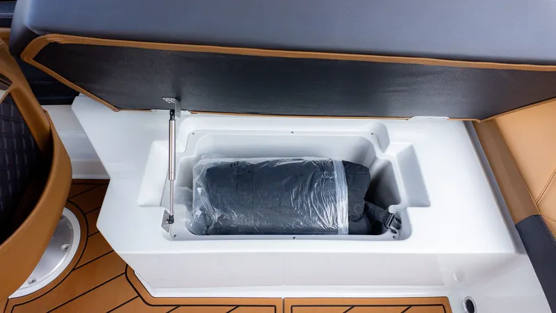 Slide: The Image of A storage compartment under a seat with a black item inside. - 28