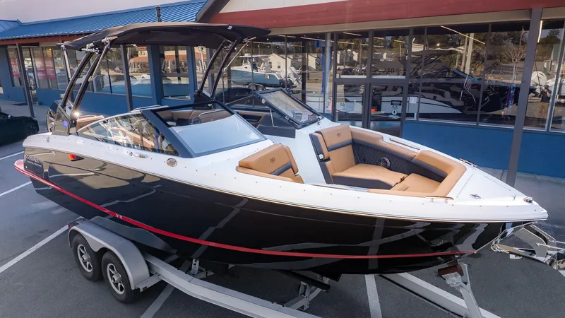 Slide: The Image of A sleek 2026 Cobalt R6B boat on a trailer, featuring modern seating and a black hull. - 32