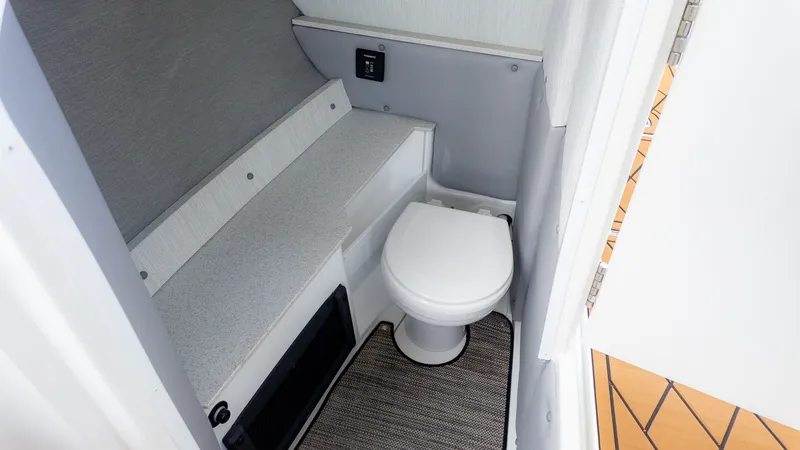 Slide: The Image of Interior view of a boat toilet with gray walls and a white toilet. - 15