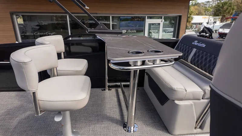 Slide: The Image of The image shows the seating area of a Barletta Lusso 25UE boat with elegant seats and a table. - 12