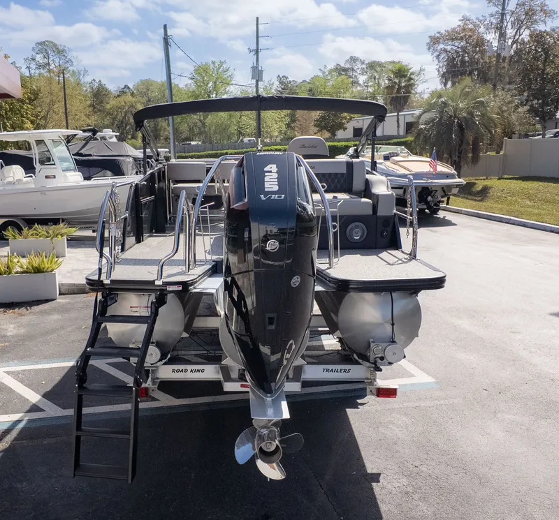 Slide: The Image of The image shows a Barletta Lusso 25UE boat on a trailer in a parking lot. - 3
