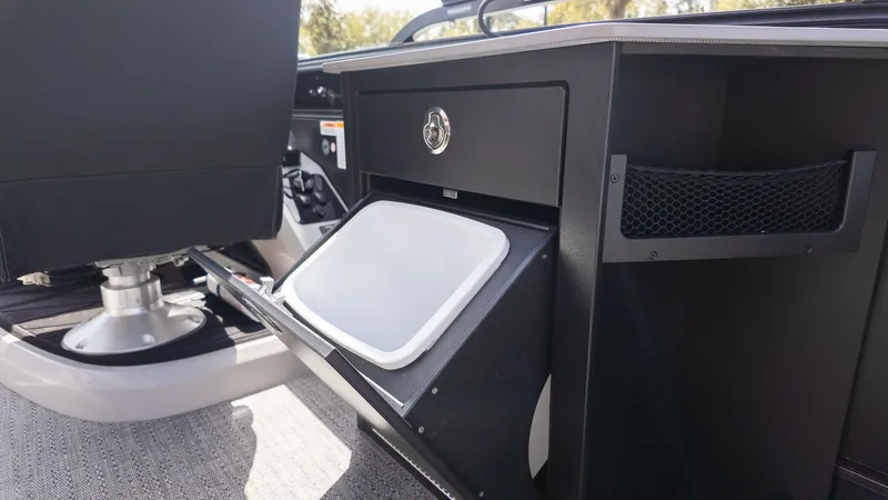 Slide: The Image of Interior of a Barletta Lusso 25UE with an open storage compartment and a seat. - 28