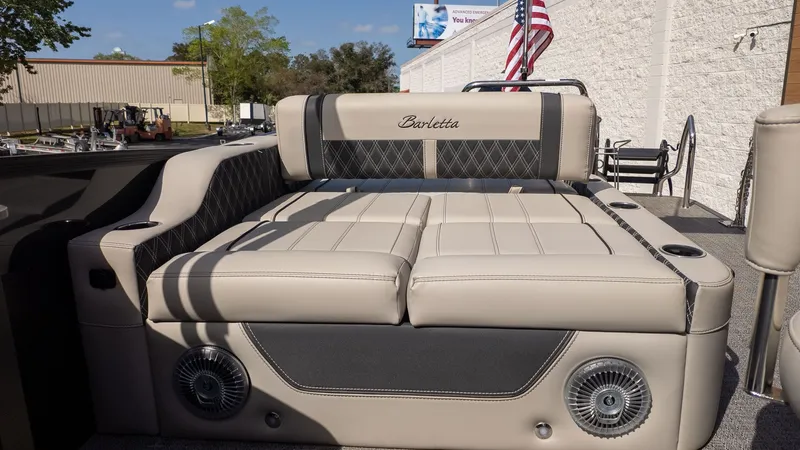Slide: The Image of The image shows the luxurious seating area of a Barletta Lusso 25UE boat with beige upholstery. - 8