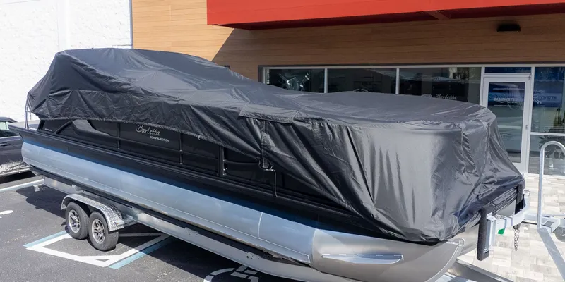 Slide: The Image of A 2026 Barletta Lusso 25UE pontoon boat, covered and parked on a trailer. - 38