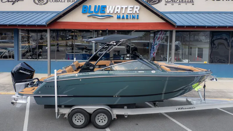 Slide: The Image of Cobalt R6 boat parked on a trailer in front of a marine store. - 28