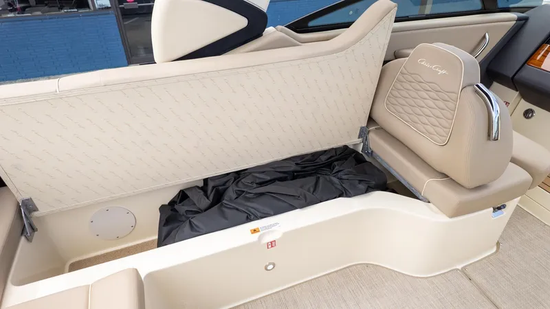 Slide: The Image of Interior view of a Chris-Craft Sportster 28 with beige upholstery and storage under the seat. - 8