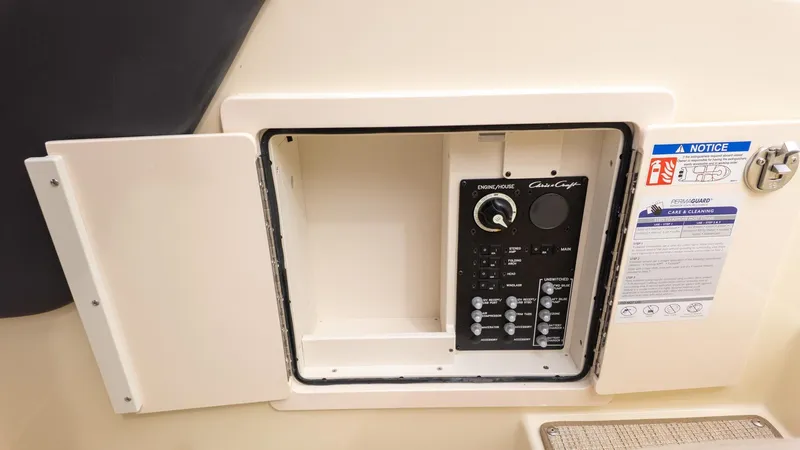 Slide: The Image of An open control panel with switches and instructions inside a boat cabin. - 28
