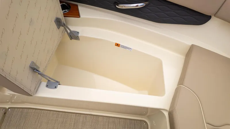 Slide: The Image of Interior view of a Chris-Craft Sportster 28 with beige upholstery and storage compartment. - 13