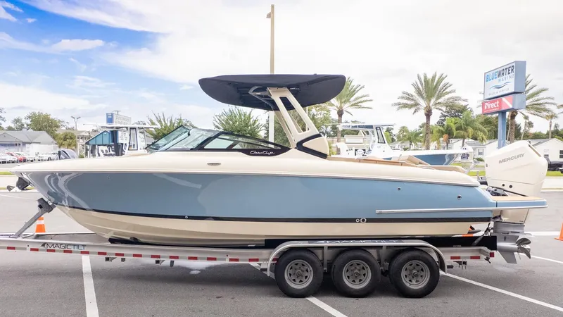 Slide: The Image of A 2026 Chris-Craft Sportster 28 on a trailer. It features a blue and cream design. - 3