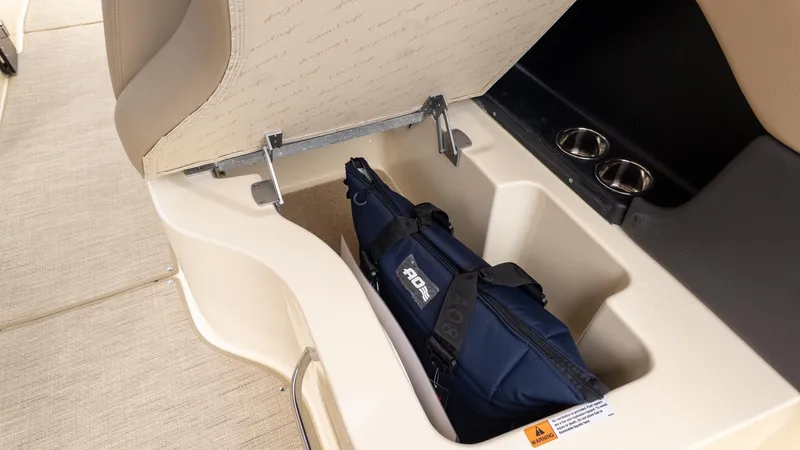 Slide: The Image of An open storage compartment with a blue bag and cup holders beside it. - 13