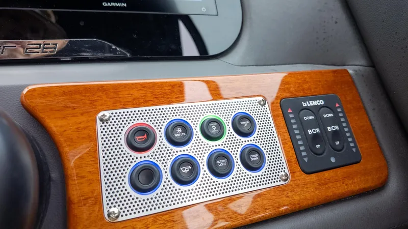 Slide: The Image of Dashboard of a Chris-Craft Sportster 28 with wood paneling and various switches. - 24