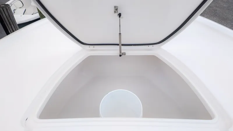 Slide: The Image of An open storage compartment on a boat with a white bucket inside. - 20
