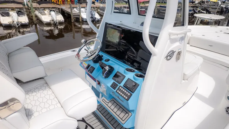 Slide: The Image of The image shows the cockpit of a Tidewater 2700 Carolina Bay boat with modern instruments. - 13