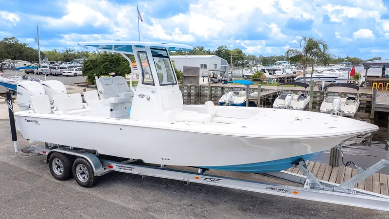 Slide: The Image of A white boat on a trailer at a dock, surrounded by other boats. - 24