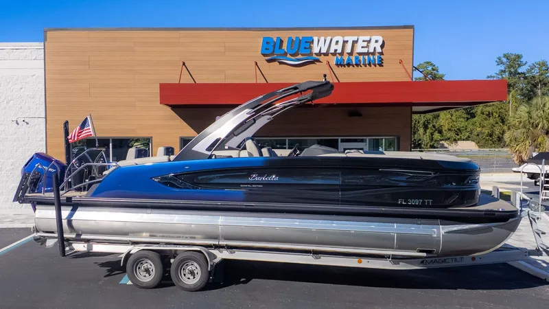 Slide: The Image of A 2024 Barletta Reserve Leggera 26MA on a trailer in front of a building. - 26