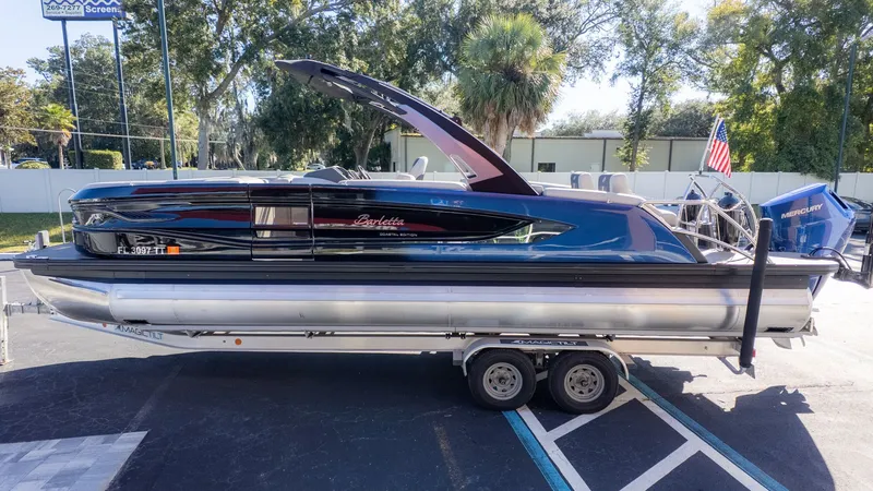 Slide: The Image of 2024 Barletta Reserve Leggera 26MA on a trailer, featuring blue exterior and American flag. - 3
