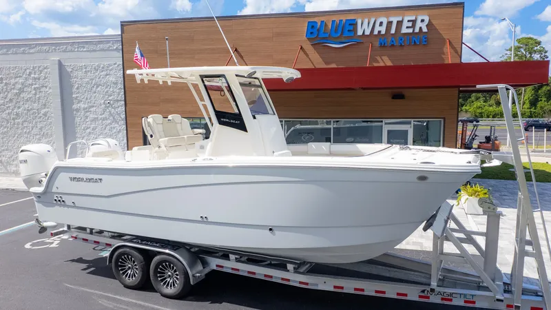 The Image of A 2026 World Cat 265CC boat on a trailer in front of a Bluewater Marine building. - 1