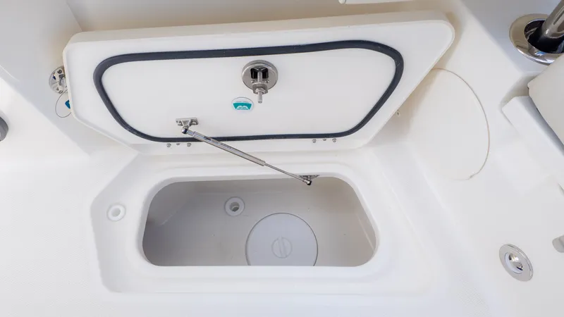 Slide: The Image of A storage compartment on a boat with a white lid and metal handle. - 27