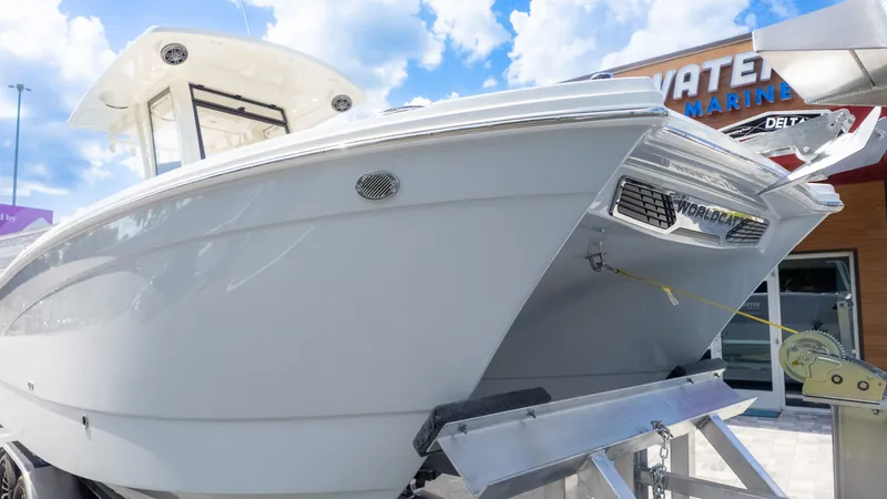 Slide: The Image of A World Cat 265CC boat on a trailer in front of a building with a blue sky. - 13