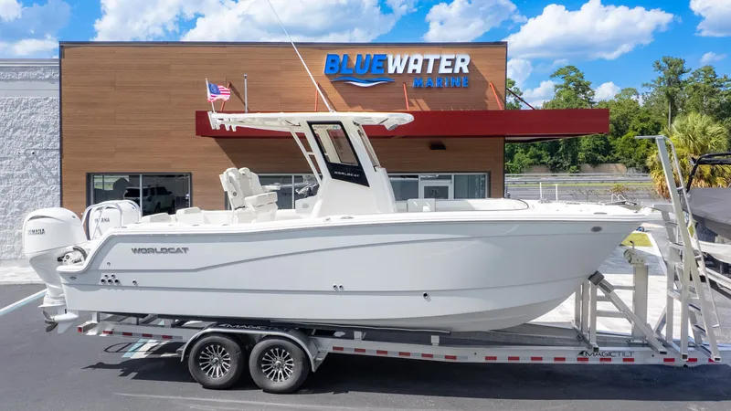 Slide: The Image of A white World Cat 265CC boat on a trailer in front of a building labeled "Bluewater Marine." - 28