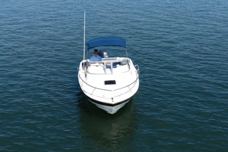 Slide: The Image of 2008 Scout 222 Abaco boat with blue canopy on calm water. - 6