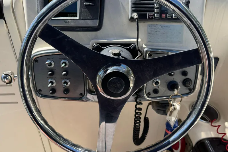 Slide: The Image of Steering wheel and controls of a 2008 Scout 222 Abaco boat. - 17