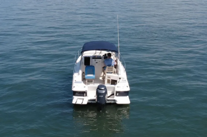 Slide: The Image of 2008 Scout 222 Abaco boat on calm water, rear view with blue canopy. - 7