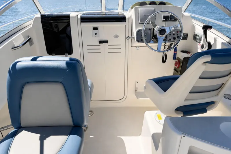 Slide: The Image of Helm of 2008 Scout 222 Abaco boat with blue and white seating, steering wheel, and controls. - 16