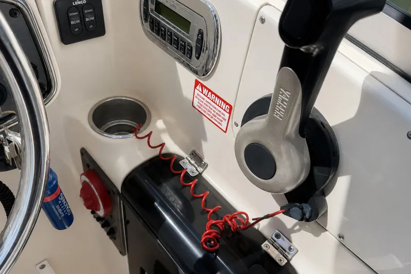 Slide: The Image of Close-up of 2008 Scout 222 Abaco boat controls, featuring steering wheel and throttle lever. - 18