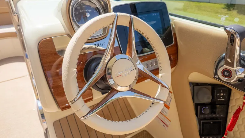 Slide: The Image of The image shows the cockpit of a Chris-Craft Launch 28 GT with a sleek steering wheel and wood accents. - 29