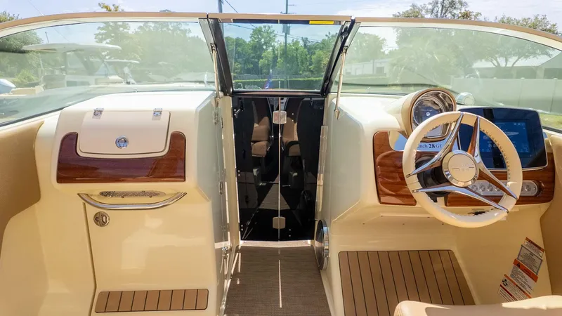 Slide: The Image of The cockpit of a 2025 Chris-Craft Launch 28 GT with elegant wood accents. - 18