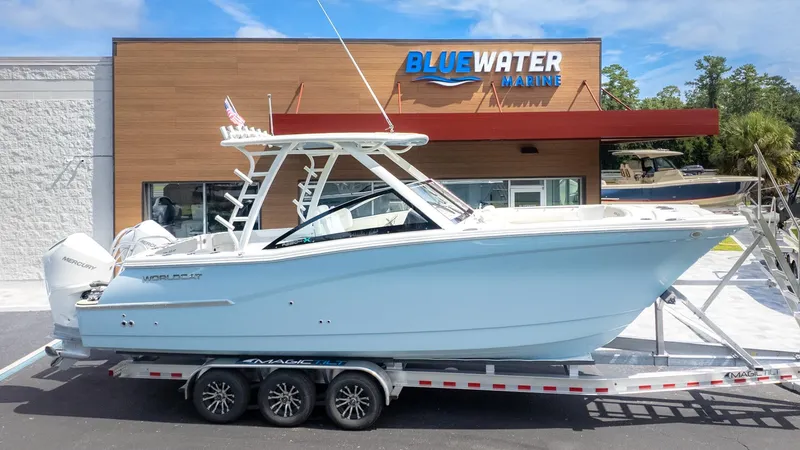 Slide: The Image of A World Cat 280 Dual Console boat on a trailer in front of a building labeled "Bluewater Marine." - 40