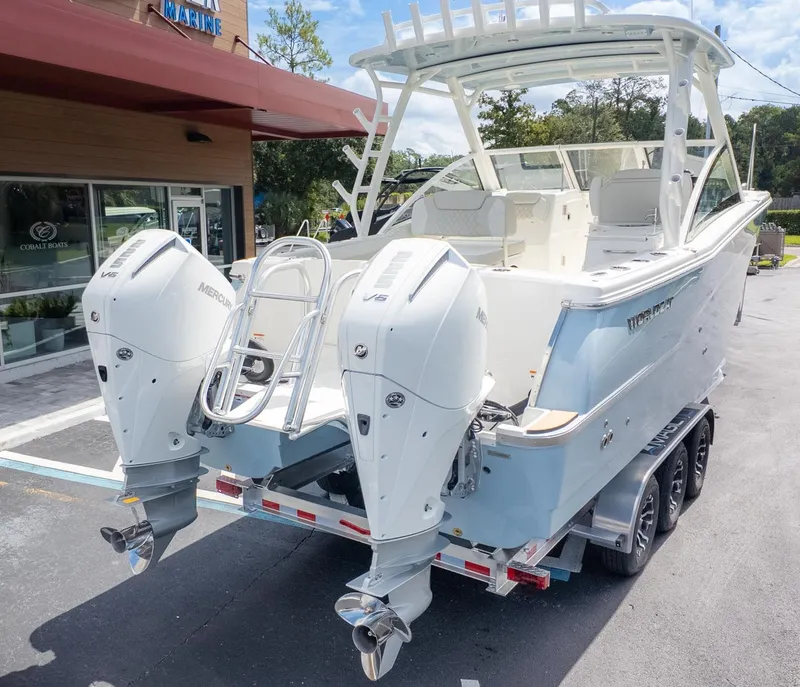 Slide: The Image of A World Cat 280 Dual Console boat on a trailer, featuring two outboard engines. - 5