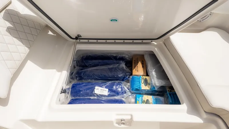 Slide: The Image of Boat storage compartment with blue tarps and accessories. - 30