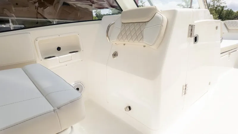 Slide: The Image of Interior view of a boat with white cushioned seating and storage space. - 23