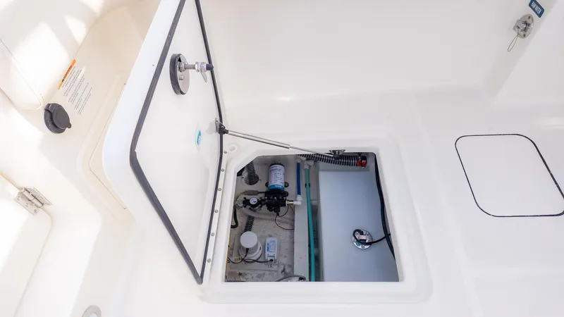 Slide: The Image of An open storage compartment on a boat with visible mechanical components. - 18
