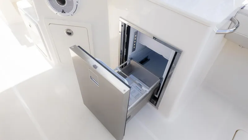 Slide: The Image of An open refrigerator or freezer on a boat with a white interior. - 16