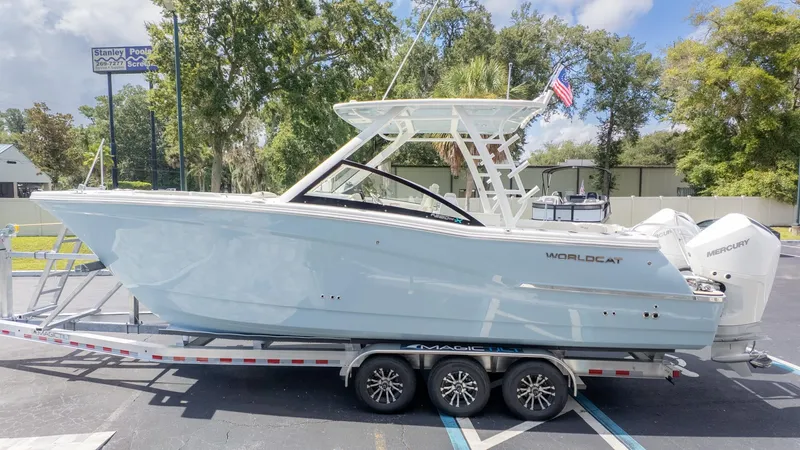 Slide: The Image of A World Cat 280 Dual Console boat on a trailer, surrounded by trees and a blue sky. - 5