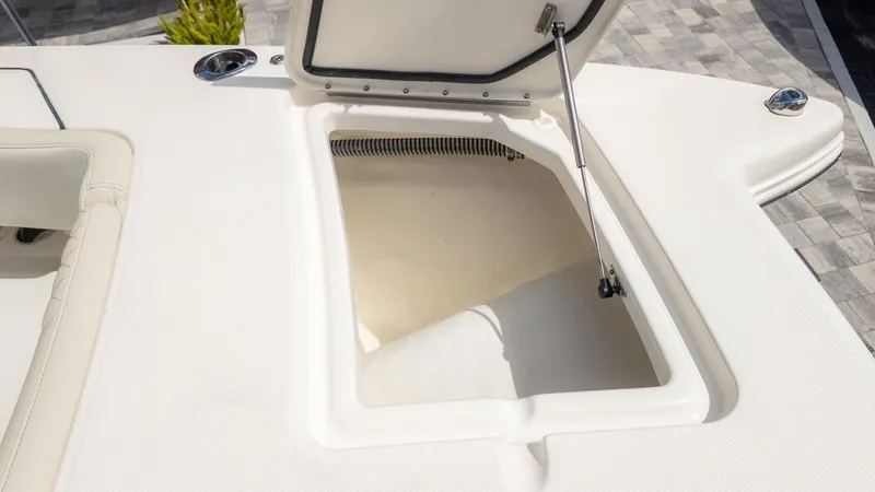 Slide: The Image of An open storage compartment on a boat with a cushioned edge and gas strut. - 32