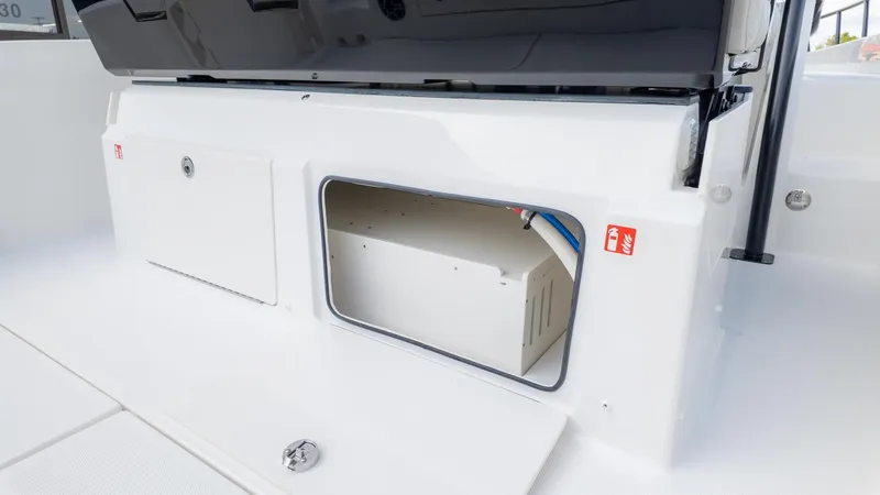 Slide: The Image of An open storage compartment on a boat with white surfaces and visible cables. - 19
