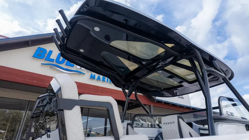 The Image of The image shows a modern boat with a sleek black roof in front of a building labeled "Blue." - 1