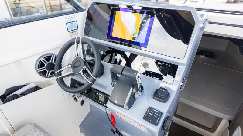 Slide: The Image of The image shows the helm of a modern boat with a large screen and controls. - 28