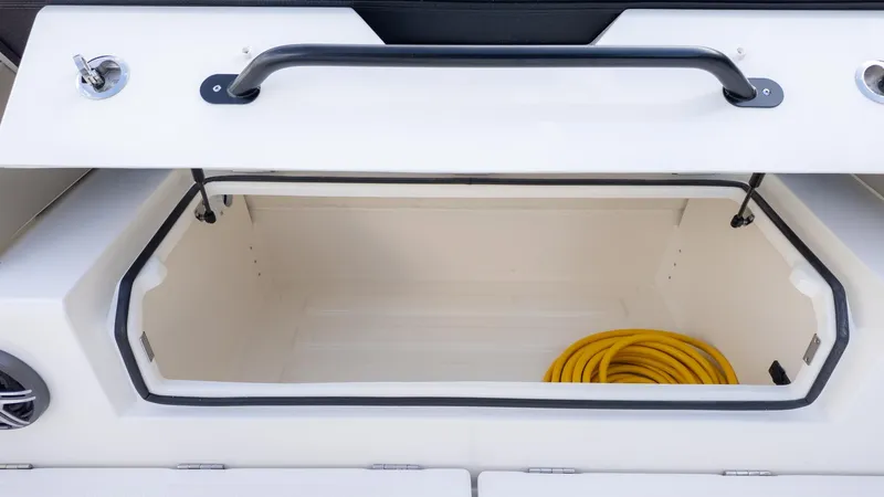Slide: The Image of An open storage compartment on a boat with a yellow hose inside. - 9