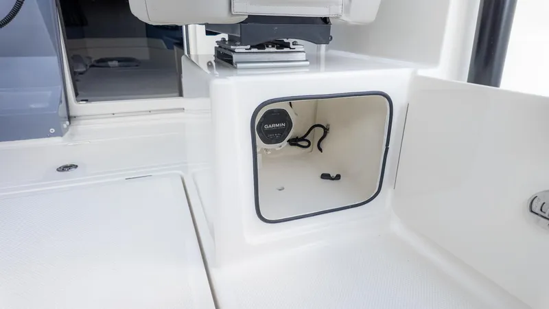 Slide: The Image of An open storage compartment on a boat with a Garmin port inside. - 22