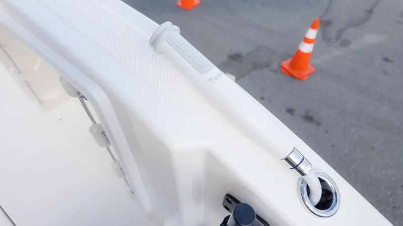 Slide: The Image of Close-up of a boat deck with a white handle and orange traffic cones in the background. - 15