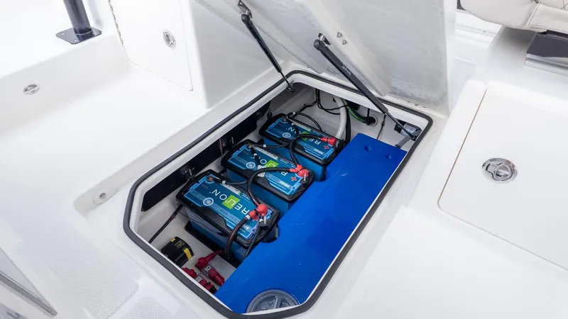 Slide: The Image of The image shows a boat's battery compartment with three blue batteries. - 23