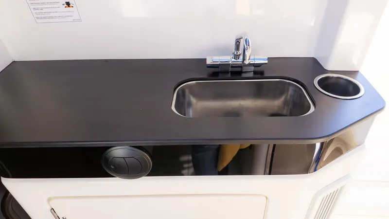 Slide: The Image of Galley area with a sink and faucet on a boat. - 22