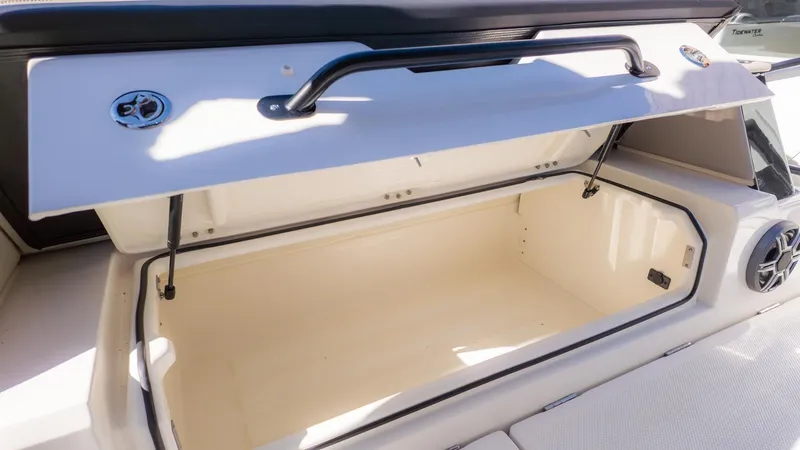 Slide: The Image of Open storage compartment on a boat with a white interior and black handles. - 10