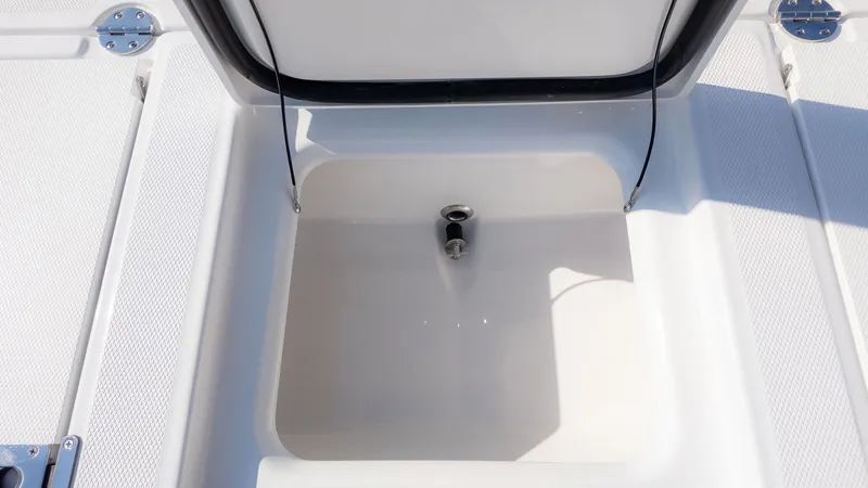 Slide: The Image of An open storage compartment on a boat with a white interior and black trim. - 12
